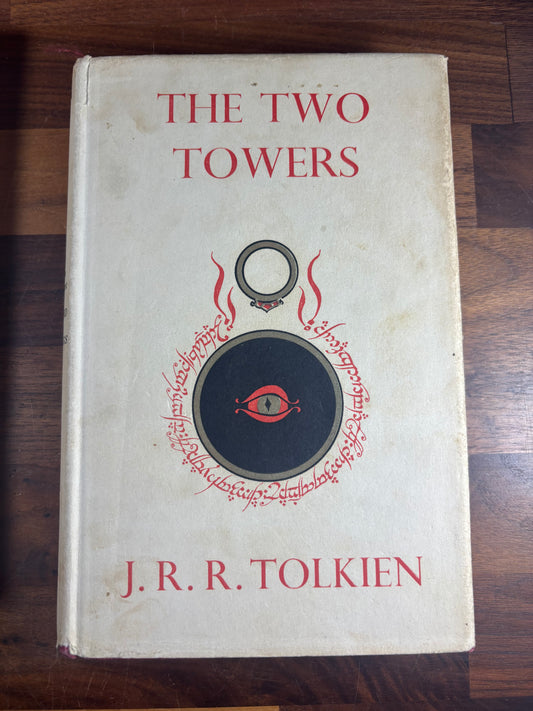Book titled 'The Two Towers' by J.R.R. Tolkien on a wooden surface